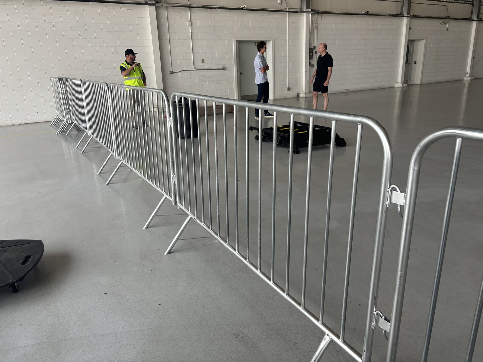 Line of interlocking steel crowd-control barricades indoors