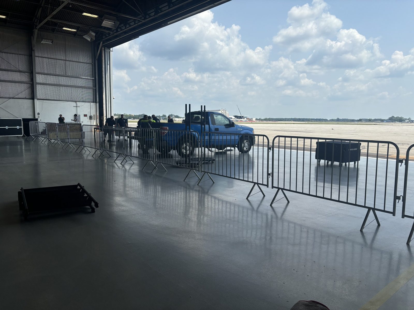 Steel barricades lined up inside an open hangar door