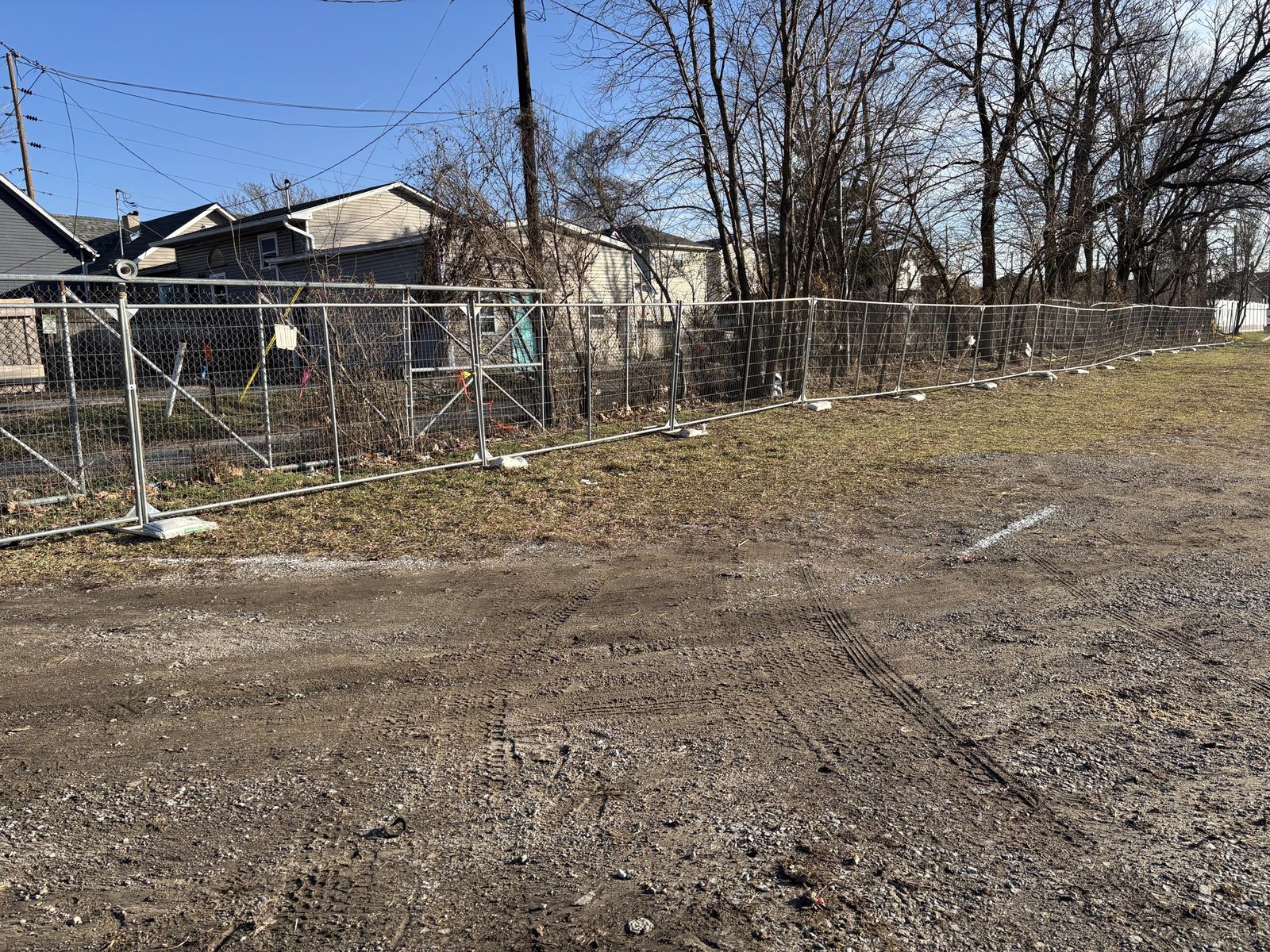 Chain link perimeter around a cleared lot in a neighborhood