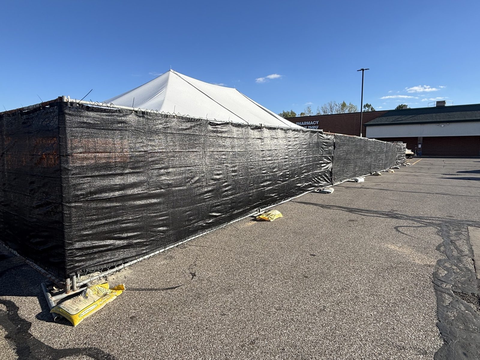 Black windscreen fitted across a panel run in front of a large white tent