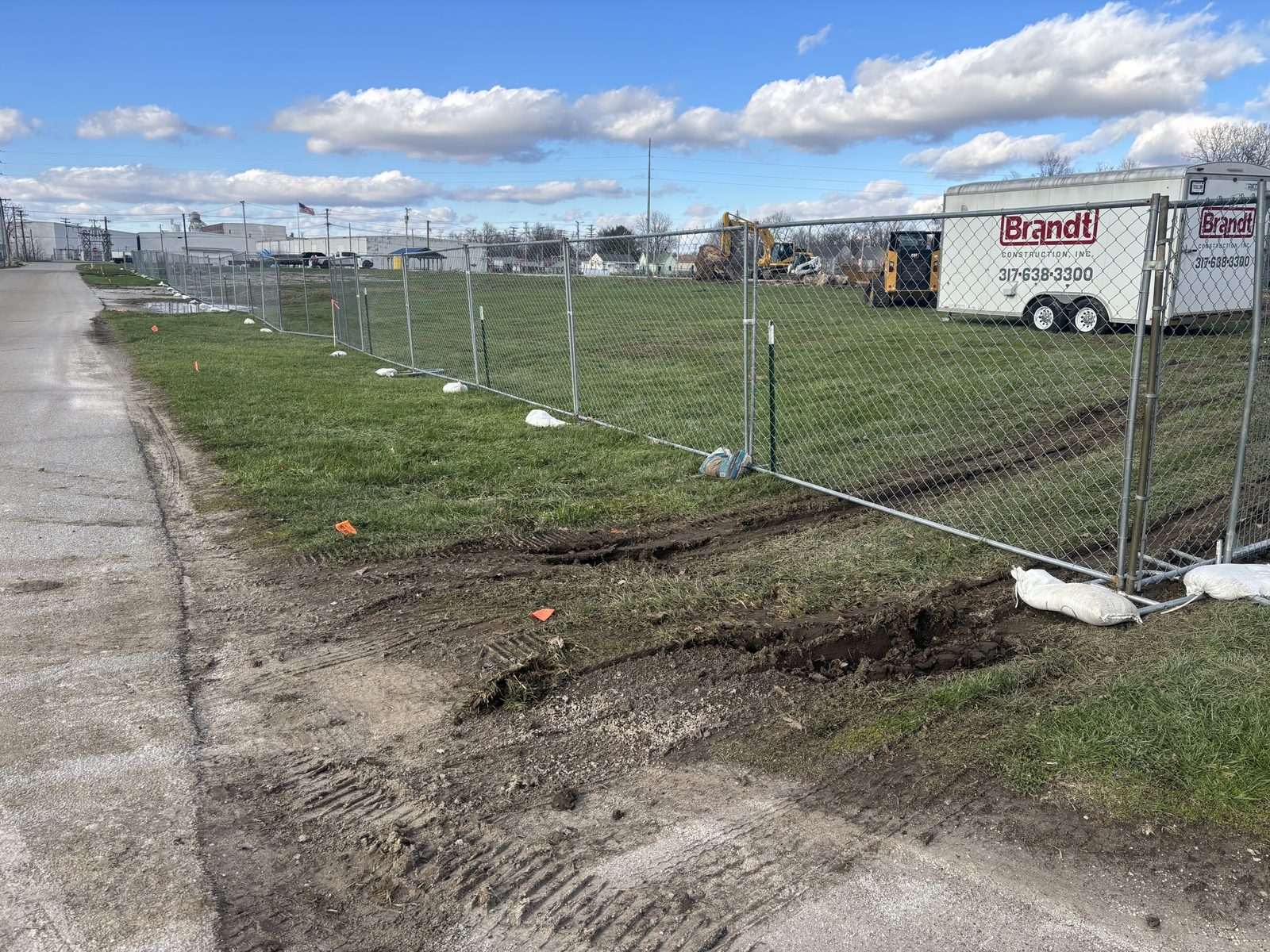 Chain link fence along the muddy edge of a grass site