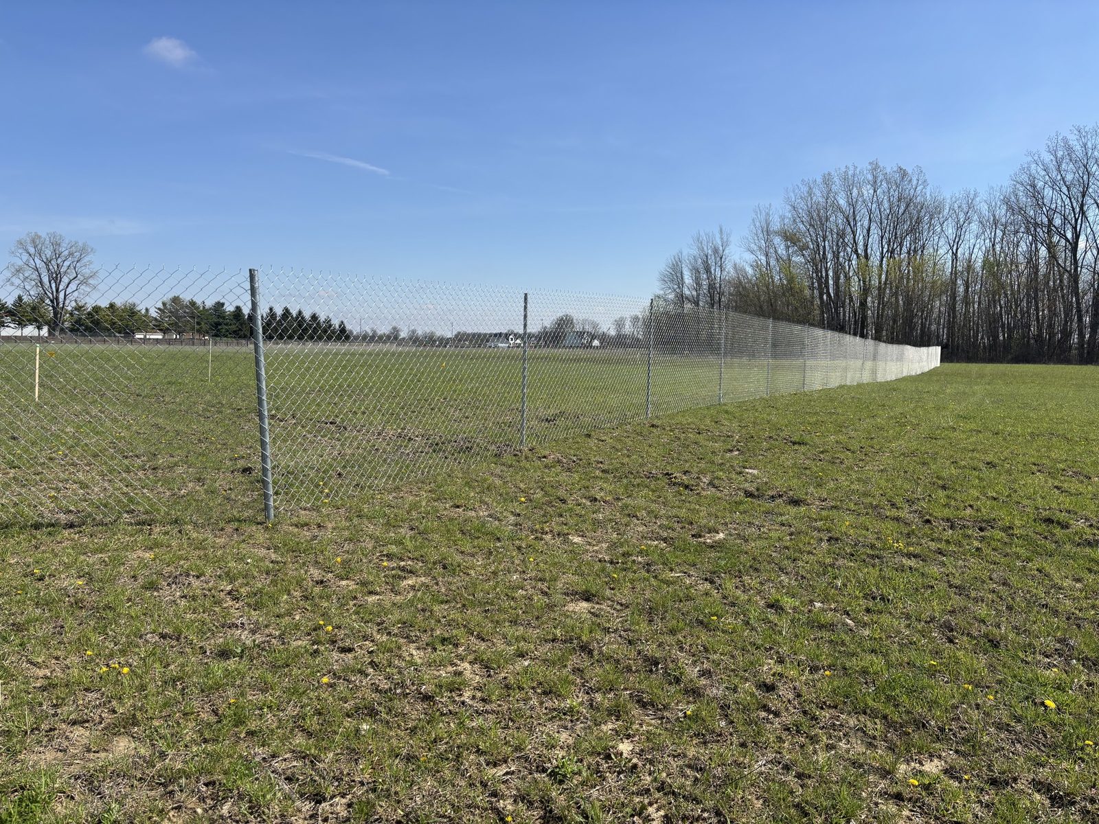 Post-driven chain link fence run across an open field