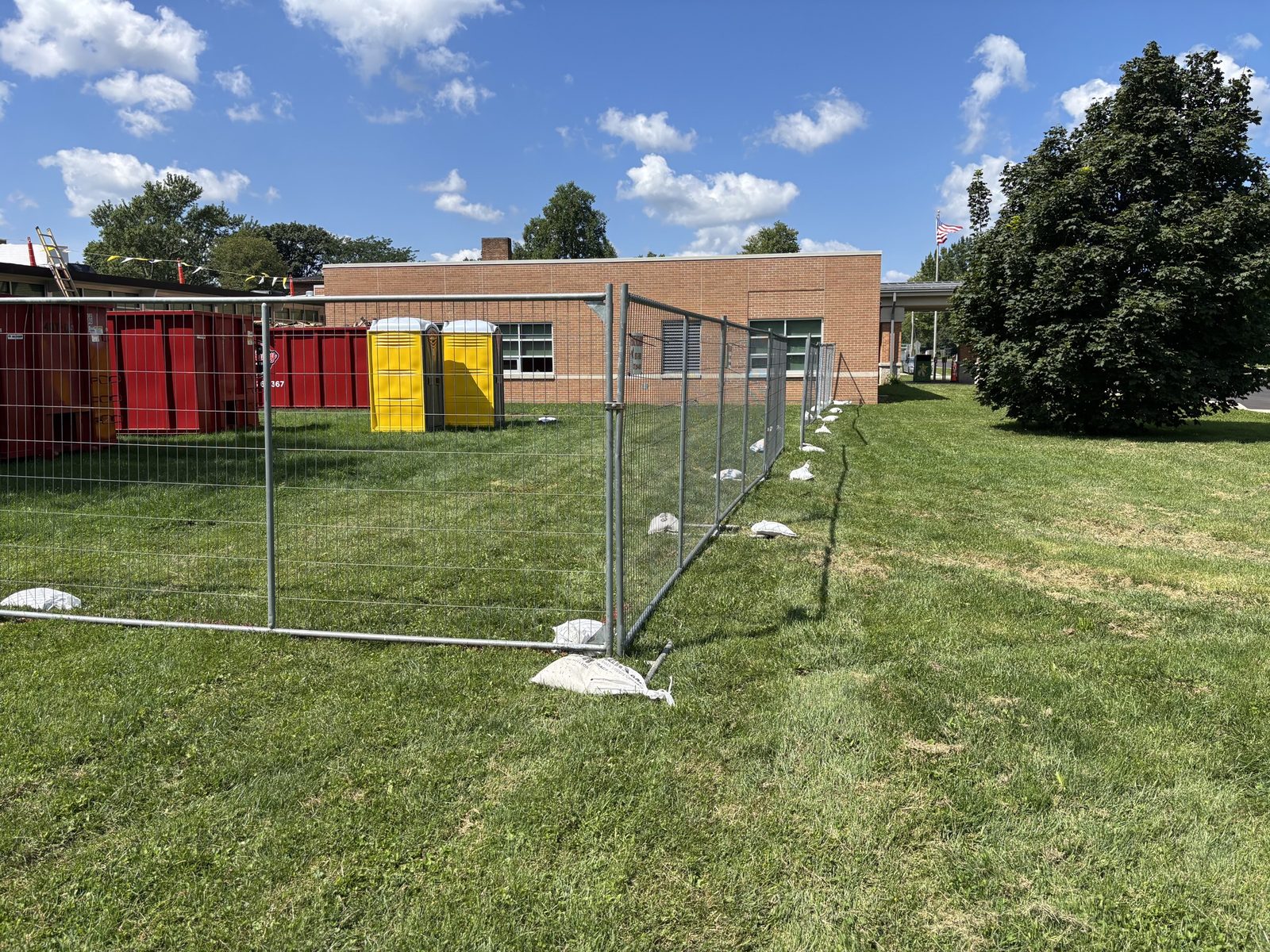 Temporary fence panels on stands outside a school building