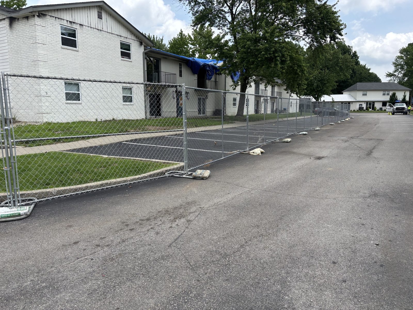 Panel fence along the edge of an apartment parking lot