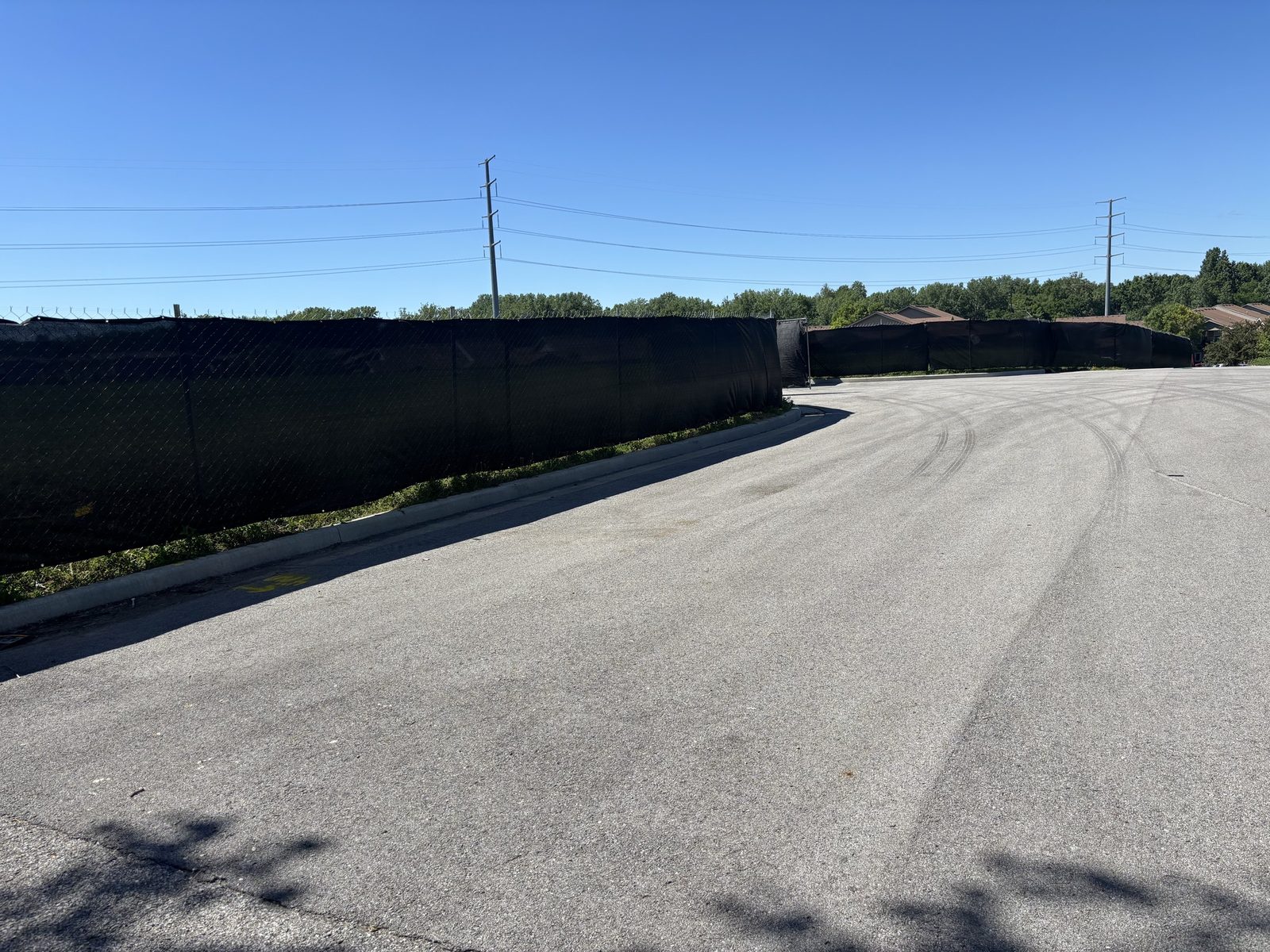 A long run of black windscreen along the edge of a paved lot
