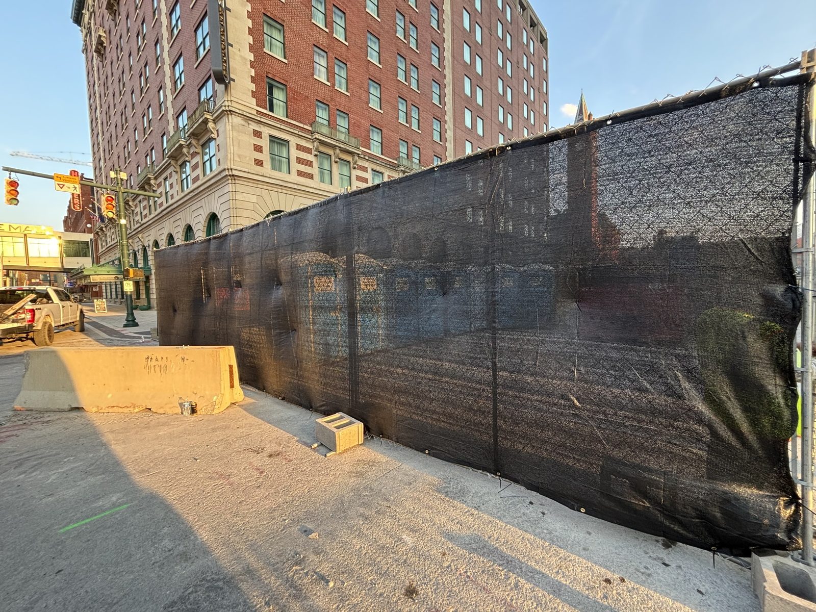 Black windscreen fitted on a fence run along a downtown building